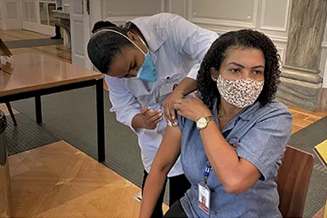 2021 Aluna do curso de Enfermagem aplicando, em colaboradora do CSI, vacina durante campanha de imunização contra Covid-19